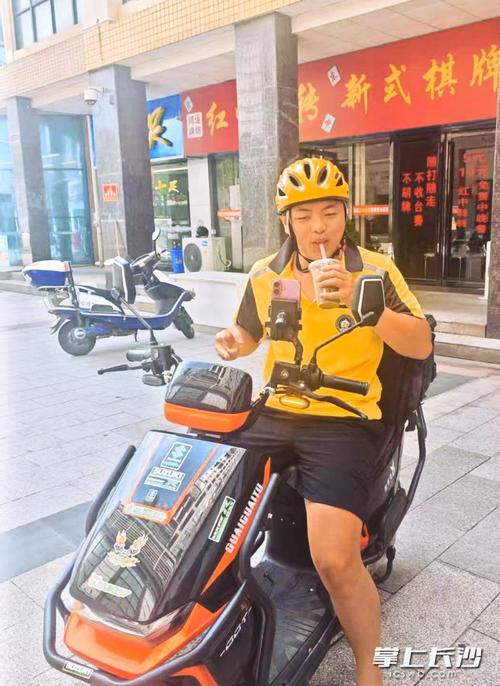 外卖小哥开心地喝粥解暑